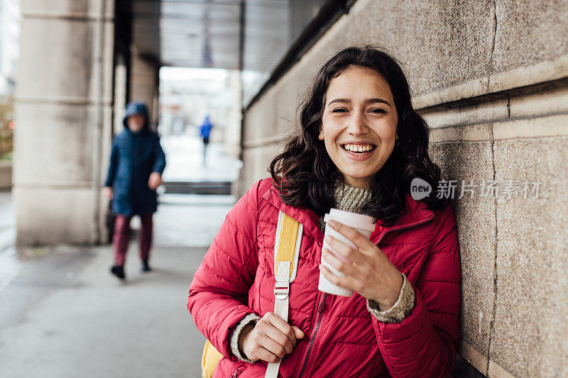 一个快乐的学生用可重复使用的杯子喝咖啡的肖像