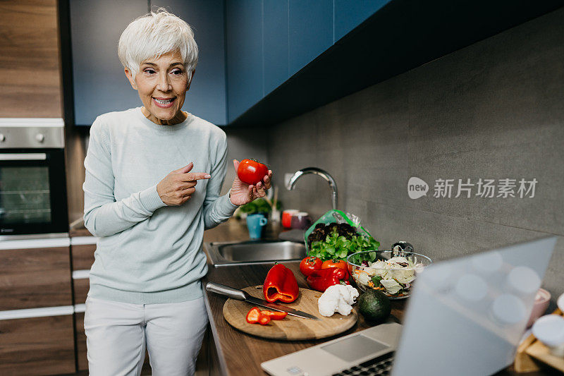 一位女士在厨房里用笔记本电脑打电话