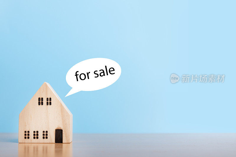 房屋模型出售蓝色背景。家庭住宅，保险和房地产投资概念。副本的空间。