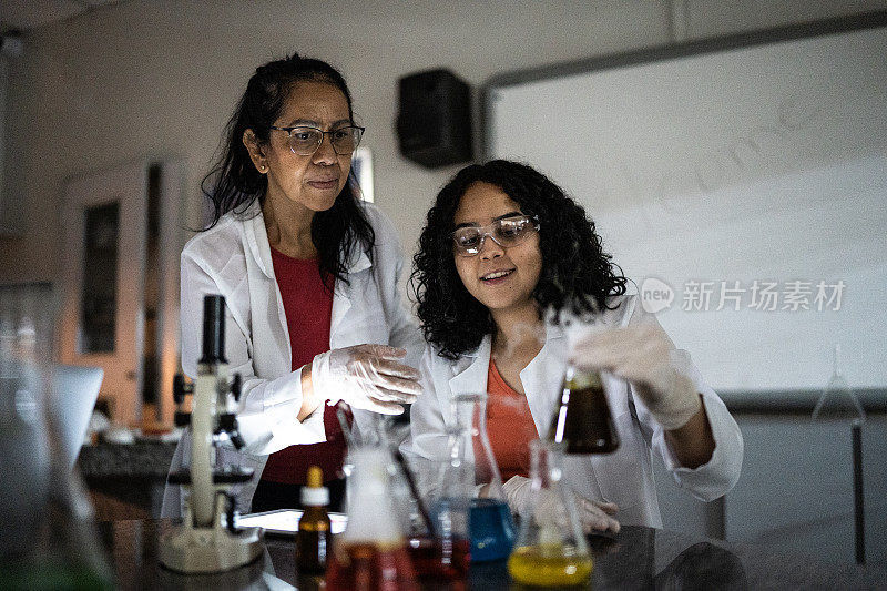 教师在学校或大学的实验室里与学生做实验