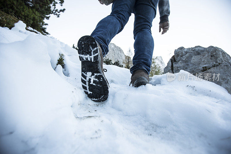 成年男子在雪中徒步旅行的低角度视图