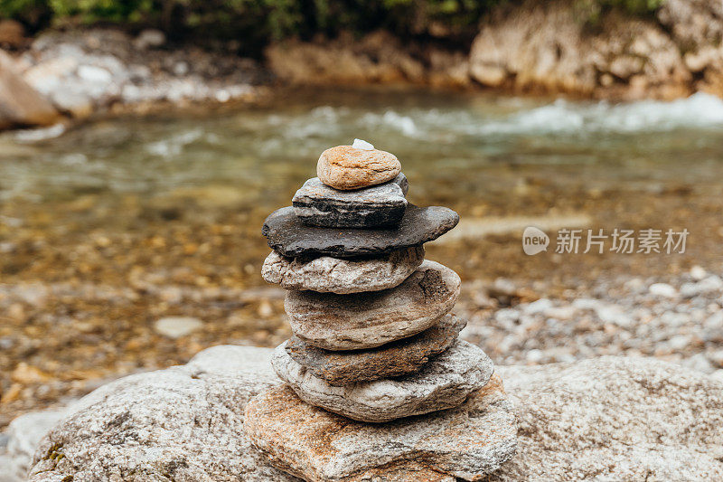 石头堆栈与平衡的石头在山的河流背景