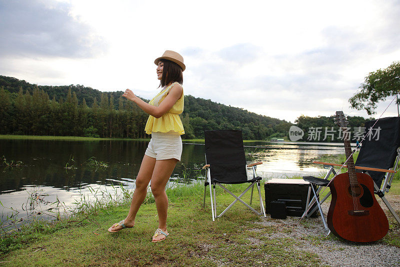 快乐的女人在湖边露营前跳舞