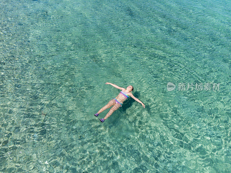 小女孩漂浮在海上的风景鸟瞰图