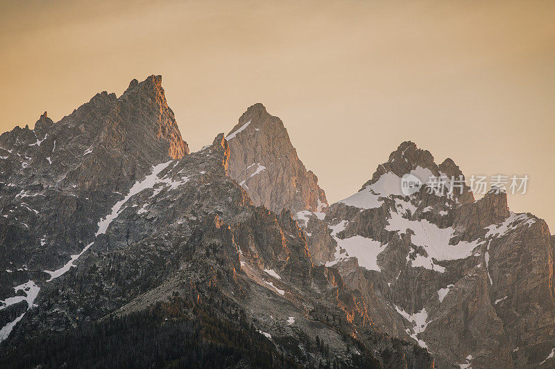 日落时分，提顿山脉金色的光芒和戏剧性的天空的特写。