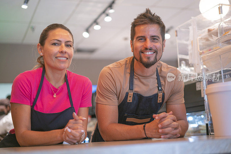 幸福的企业家夫妇肖像在咖啡店柜台