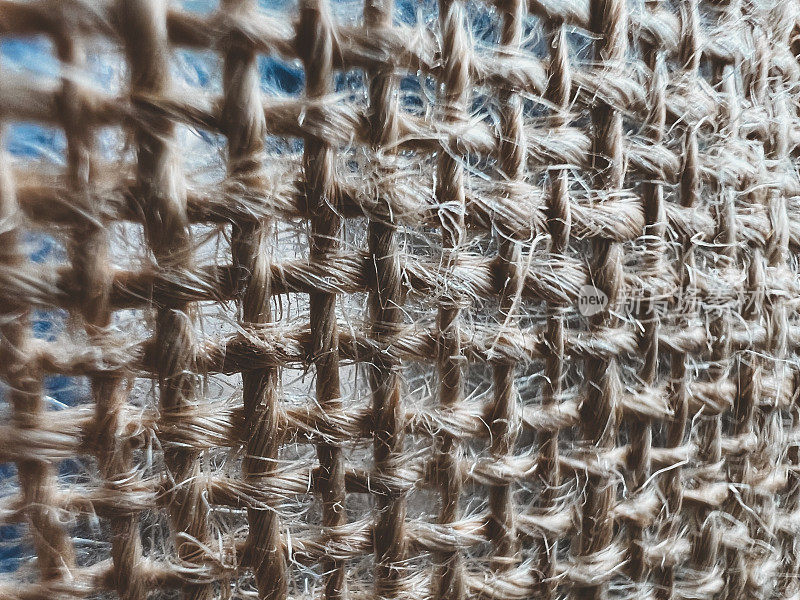 用非常粗糙的米色纱线编织的织物的微观图像。