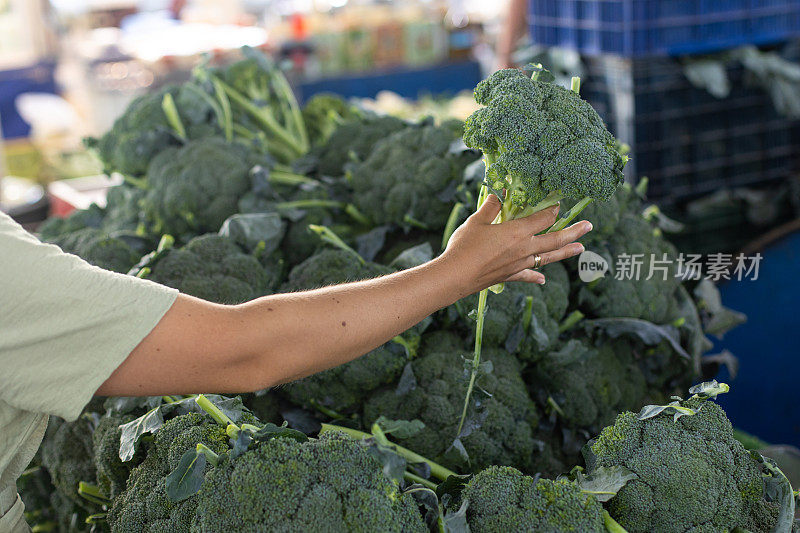 一位妇女在街市上购买新鲜的有机水果和蔬菜