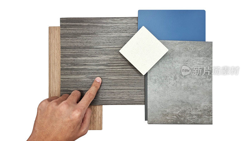 设计师的手选择现代室内材料样品，包括石英石，混凝土乙烯基地板，蓝色层压，橡木和胡桃木贴面，背景上隔离的剪切路径。