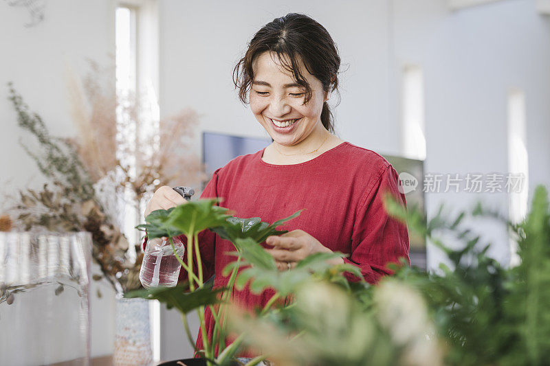 女人在家用无线耳机听音乐和园艺