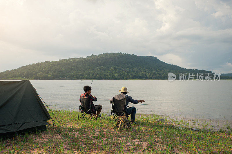 友谊的渔夫或垂钓者一起露营，坐在椅子上在湖边钓鱼。