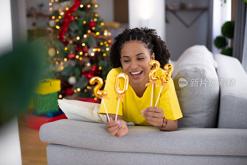 快乐的女人在家里庆祝新年库存照片