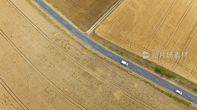 收获的麦田和乡村道路的鸟瞰图