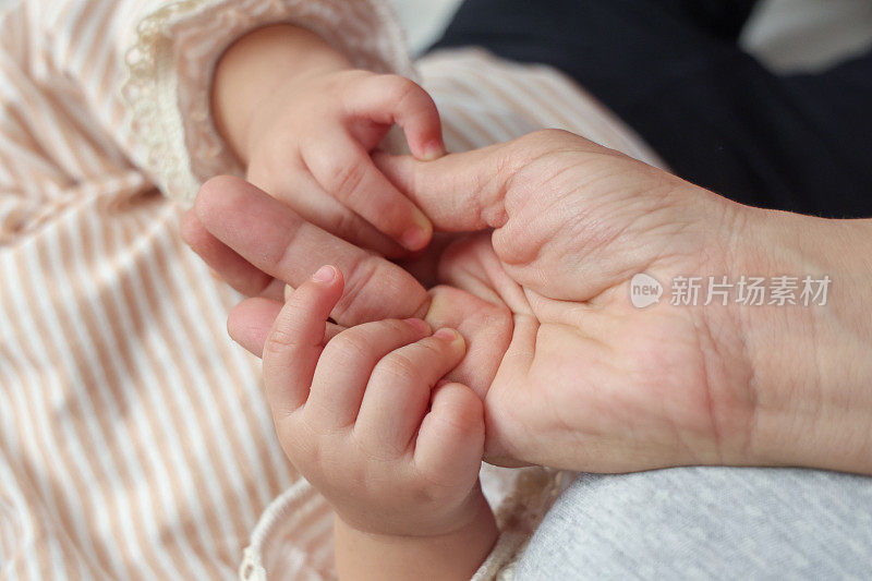 小女孩握着妈妈的手