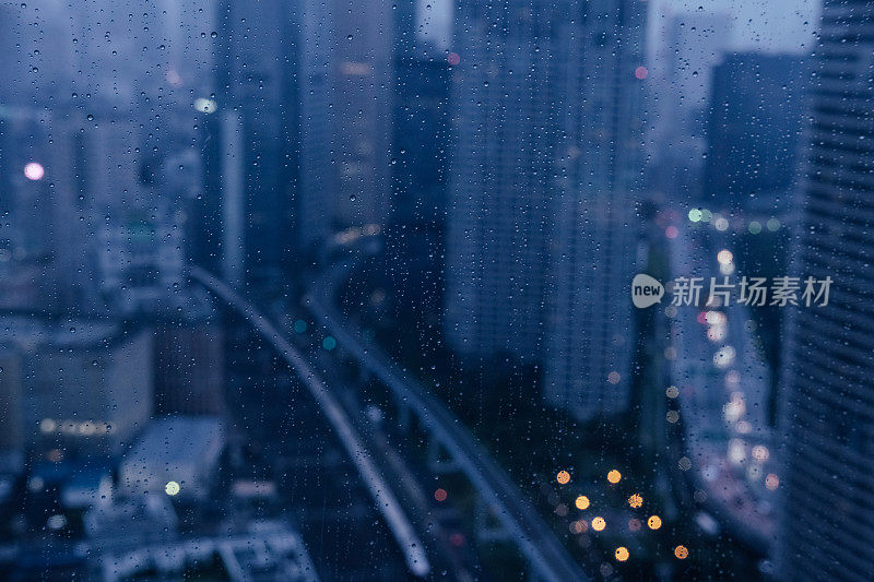 透过高层玻璃看雨中的小镇