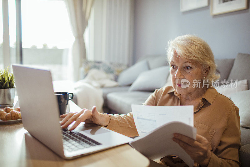 一个年长的女人在看她的账单