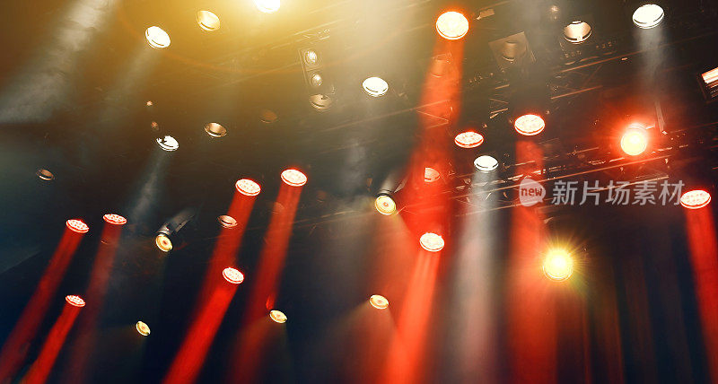 天花板上黄色和红色的聚光灯穿过舞台上的薄雾