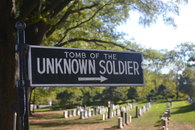黑色和白色的标志“无名战士之墓”放置在一排坟墓旁边