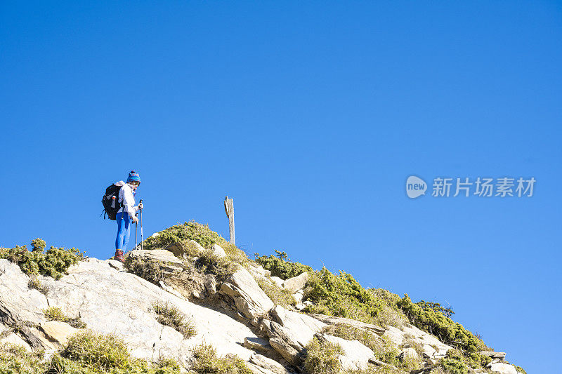 徒步旅行者站在山顶上看风景。