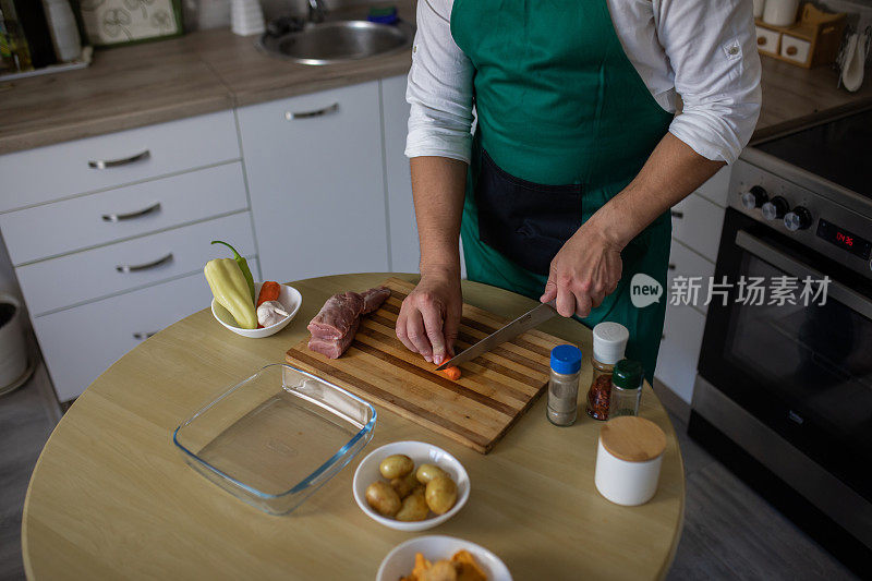 一个年轻人在厨房里为晚餐切菜的特写。用爱烹饪。