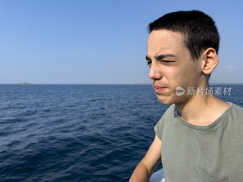 这个男孩正在北爱琴海的一艘男孩游船上旅行。体贴又快乐。晴朗的夏日。旅游的背景。旅游的概念。