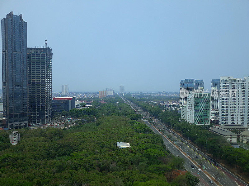高角度观看雅加达印尼城市景观与塔式建筑，公路街道和绿色公园