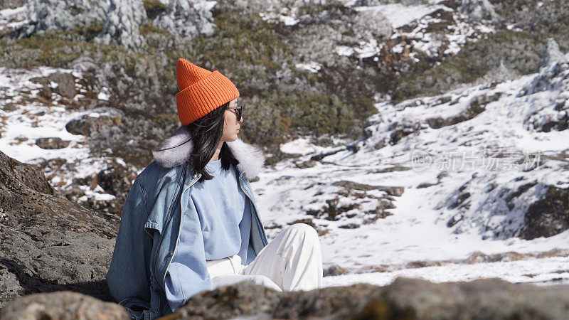 一个女人在寒冷的天气里穿行于白雪覆盖的山林之中