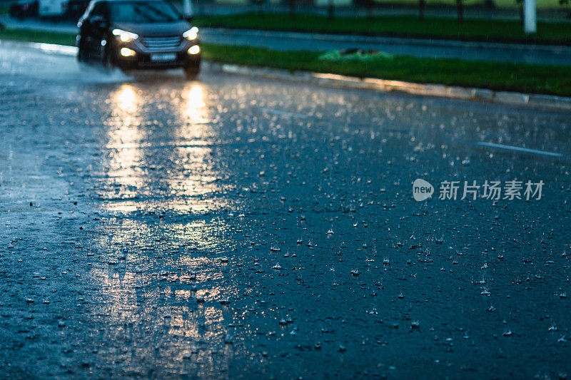 汽车驶过水坑。水溅。坏天气。暴雨