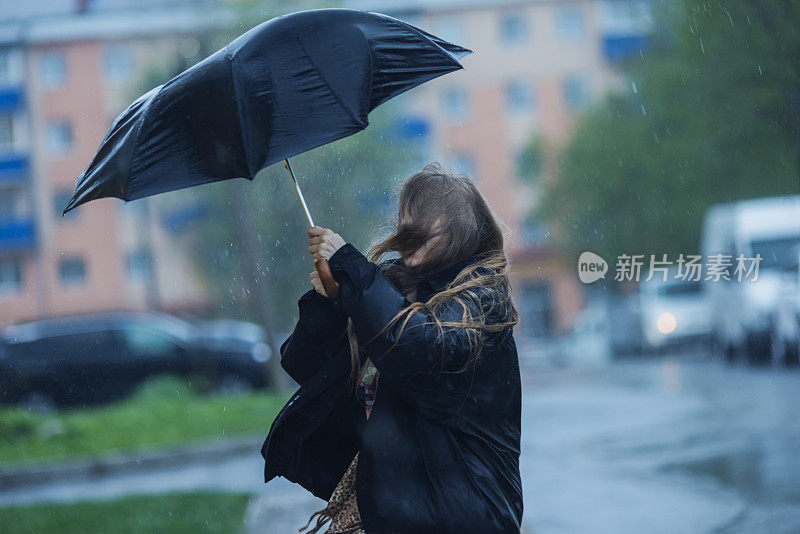 伞下的金发女人。暴风雨天气。暴雨