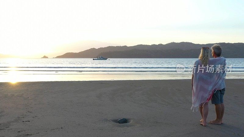 清晨，一对成熟的情侣在沙滩上放松