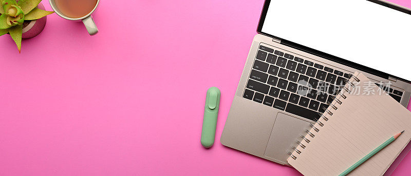 有笔记本电脑，文具和复印空间的粉红色平面工作空间