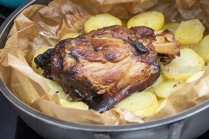 火腿蹄(或hough)或猪蹄在土豆床上烤