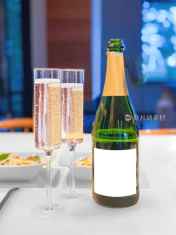 空白标签的香槟瓶和两个杯子