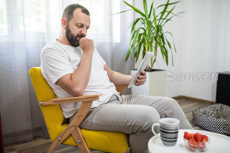 男人在家里使用数字平板电脑