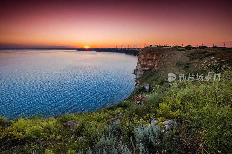 日落景观与风力涡轮机海边