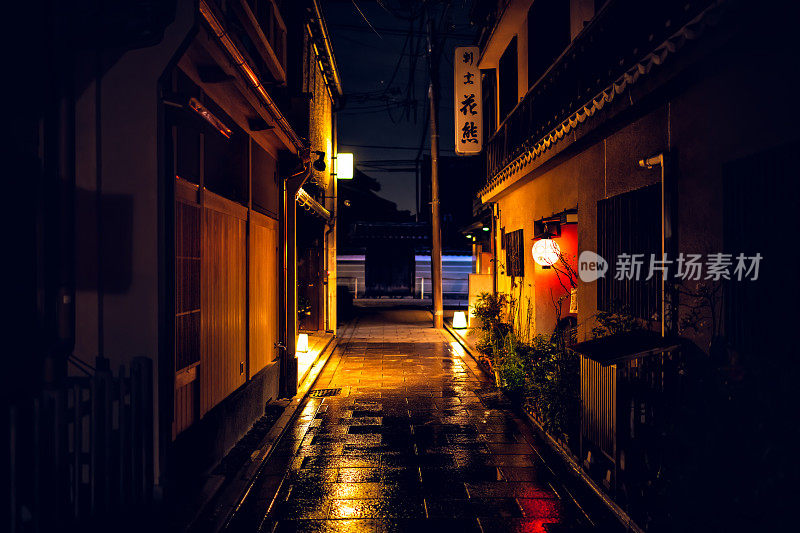 空旷的小巷狭窄的街道在Gion区晚上与餐馆外部和雨后潮湿的道路