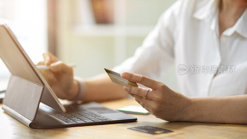 持有信用卡的女性，通过电子平板电脑登录她的网上银行账户