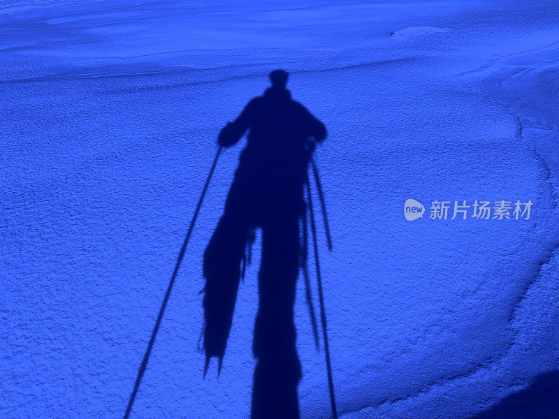 一个登山者的影子在夜晚的雪地里