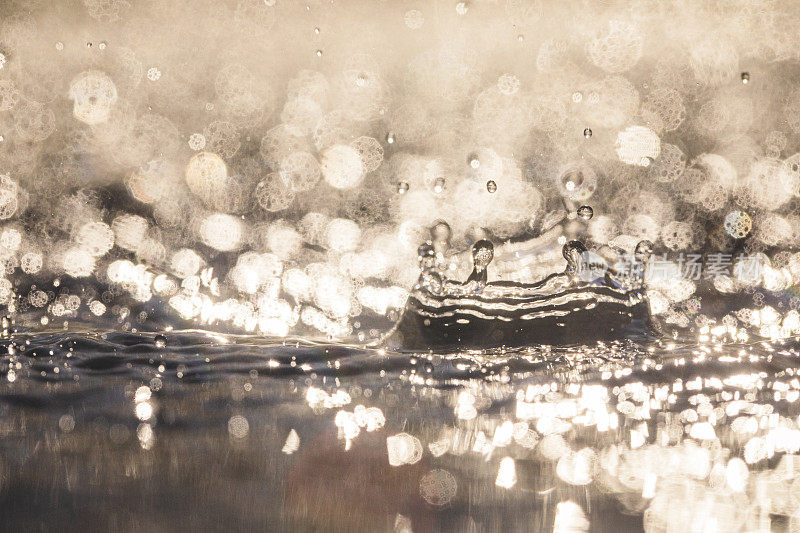 光线照射在雨滴落在水面上