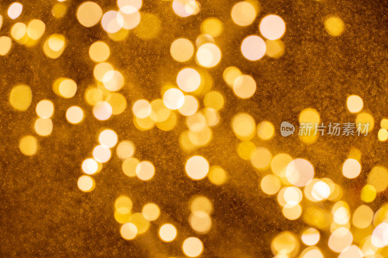 圣诞和新年快乐在模糊的金色散景横幅背景上。