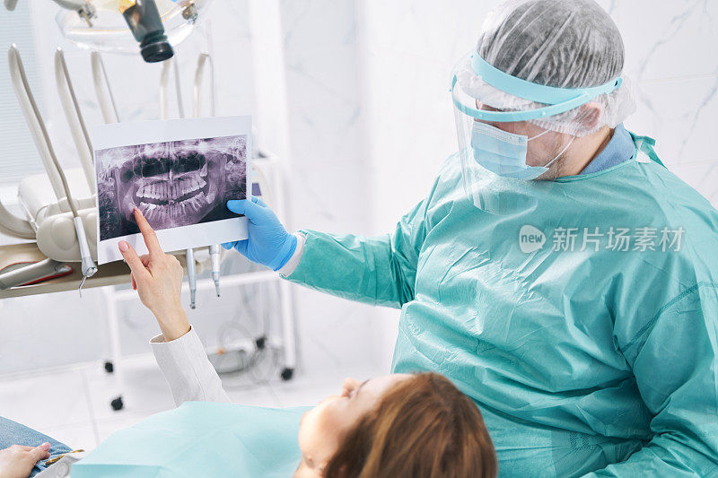 牙科医生在口腔诊所向妇女展示牙科扫描图