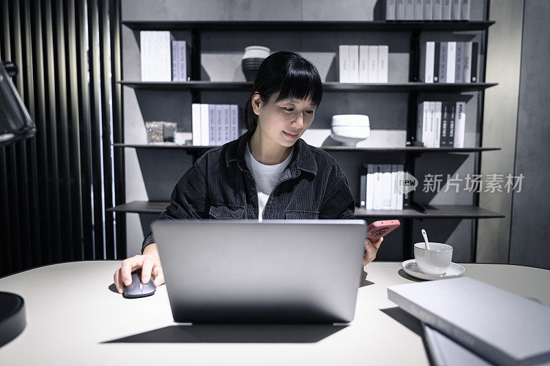 一名年轻女子在办公室使用手机。