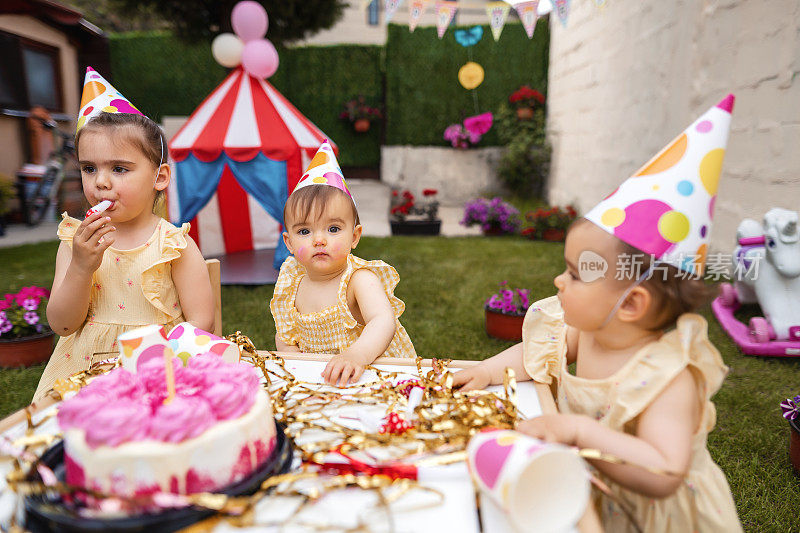 一对双胞胎姐妹和一个姐姐庆祝她们的第一个生日