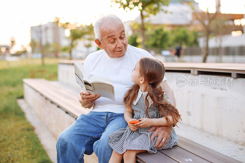 爷爷在大自然中给小孙女讲故事。
