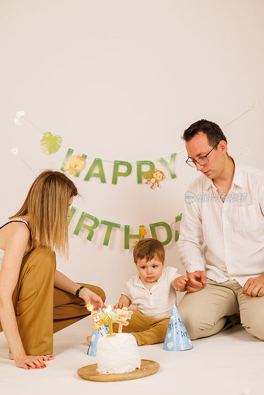 快乐的家庭用室外的生日蛋糕庆祝宝宝的第一个生日