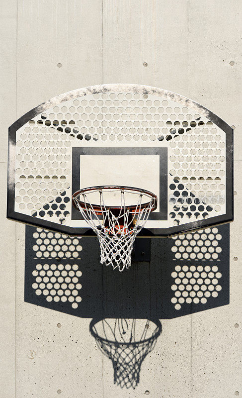 白色混凝土墙上有影子的篮球框