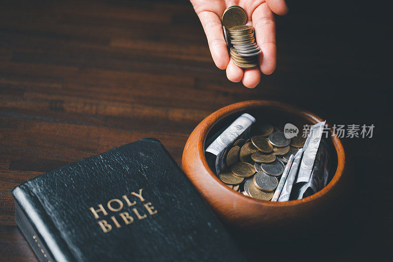 十分之一或十分之一是圣经教导我们将初熟果实的十分之一献给神的基础。印有《圣经》的硬币。圣经中关于基督徒奉献、慷慨和在教堂奉献什一税的概念。