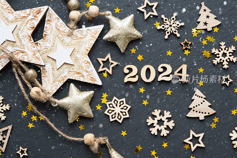 新年快乐木制字母和数字2024在节日的黑色背景与亮片，星星，雪。问候,明信片。日历,封面