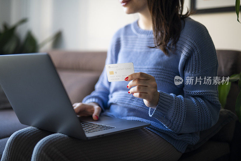 女人在家里用笔记本电脑网购。