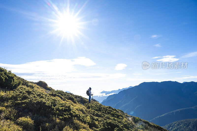 女徒步者独自走在山顶上的剪影。